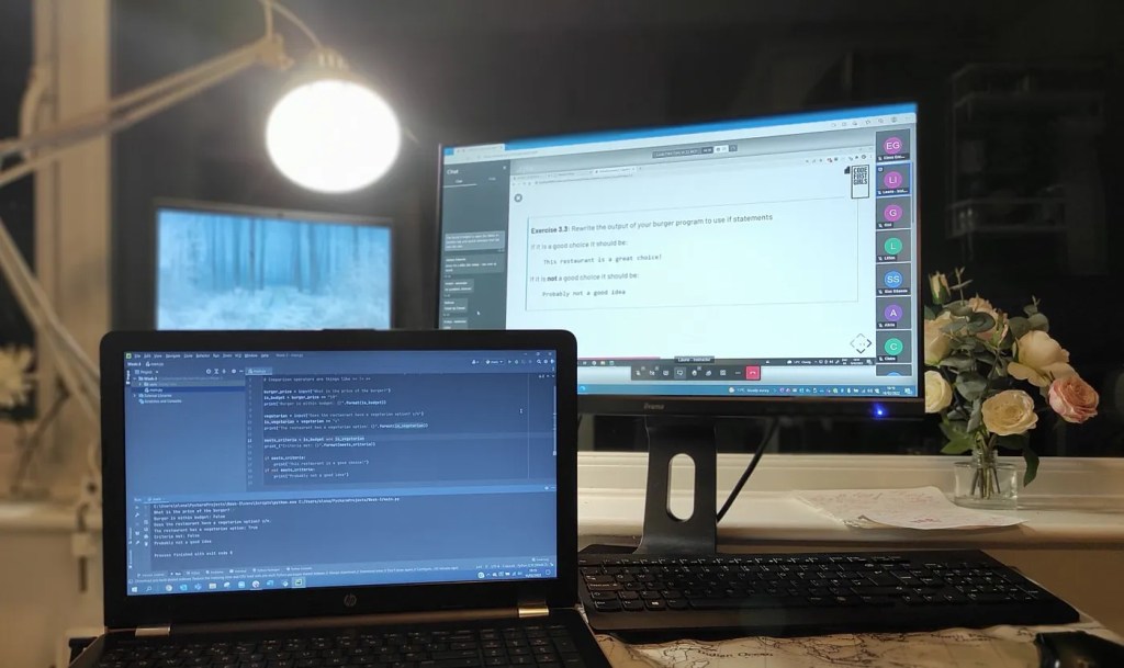 Three computer screens in front of a dark window - I chose an evening course!