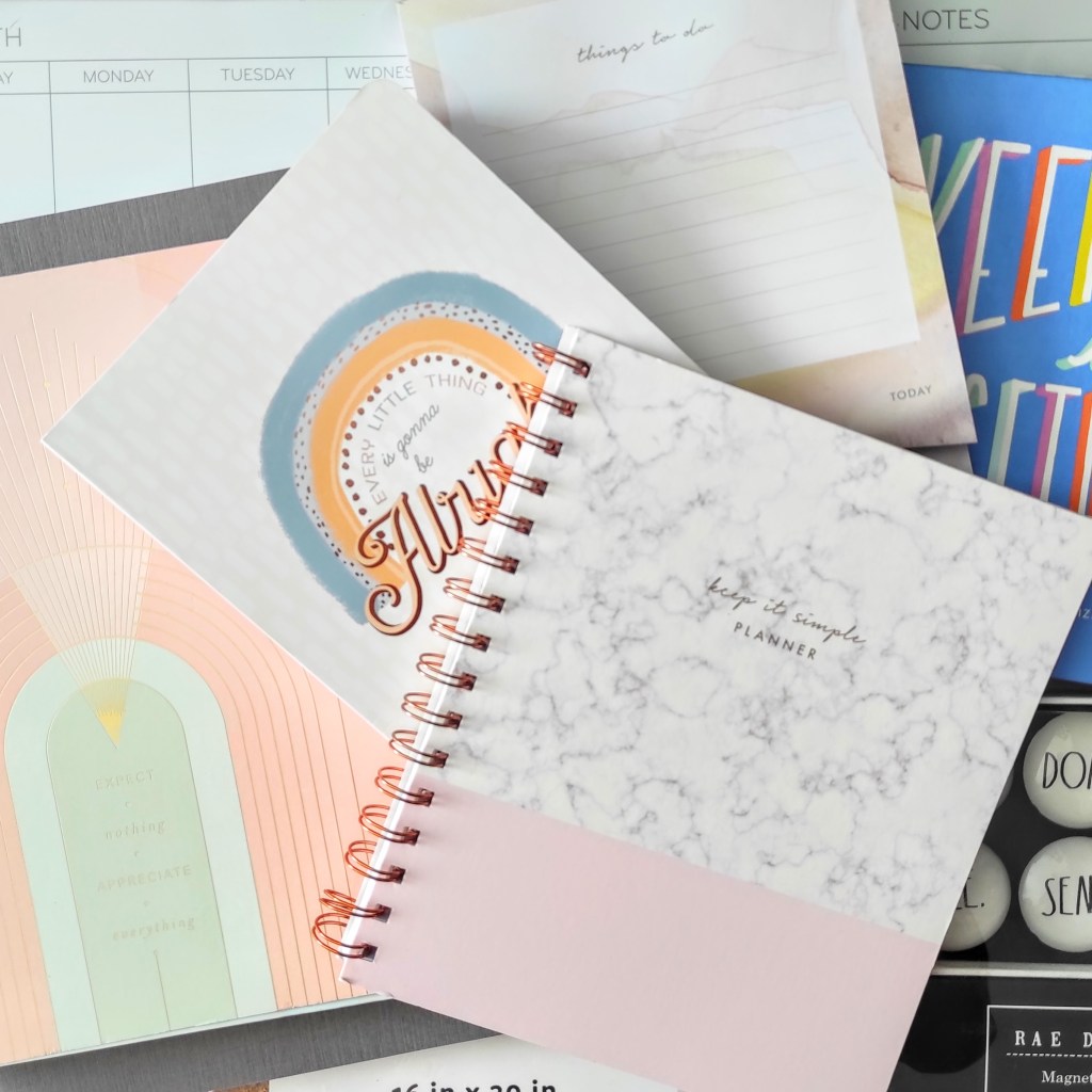 An arrangement of pastel-coloured diaries, planners, and to-do notebooks.